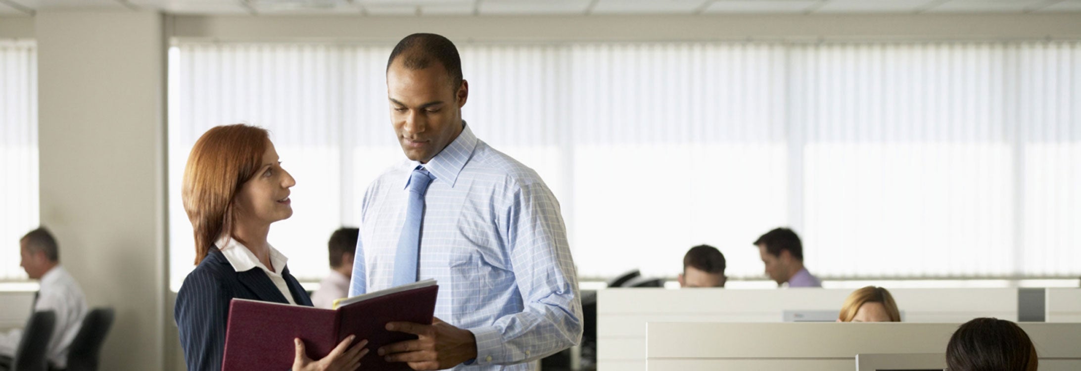 Young businessman and woman looking at diary in office